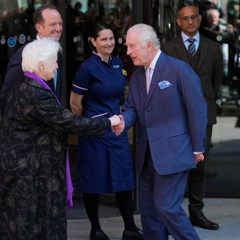 König Charles III.(M) und Königin Camilla (r) von Großbritannien werden bei ihrem Besuch im Macmillan Cancer Centre des University College Hospital begrüßt.  (Foto: dpa Bildfunk, picture alliance/dpa/AP | Kin Cheung)
